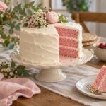 Gâteau blanc découpé révélant des couches roses pour une gender reveal.